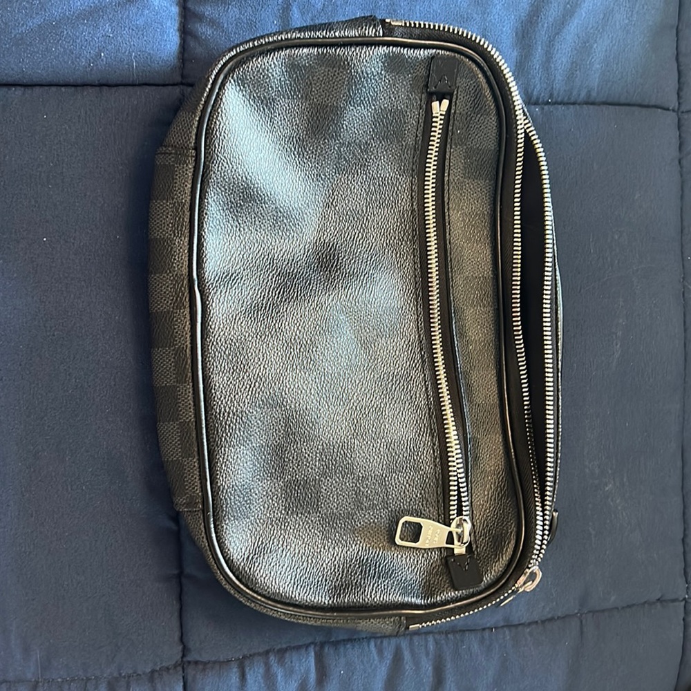 Black and grey checked Louis Vuitton pouch.